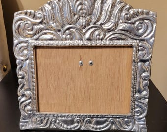 Vintage Mexican pewter picture frame features an ornate repoussé design with scrollwork