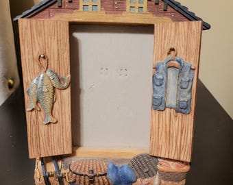 Figi Graphics 1990s picture frame features a realistic log cabin texture with fishing gear details