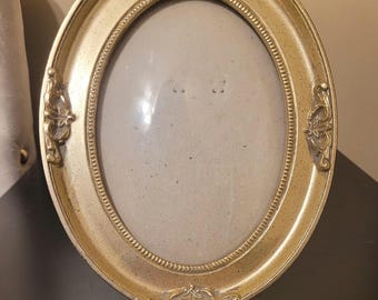 Vintage Victorian Gold ornate gold oval picture frame features decorative bow details and a beaded inner border.