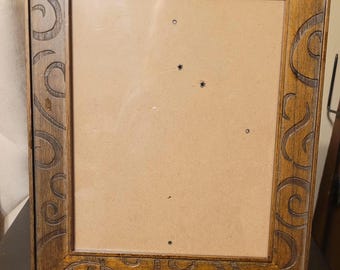 Vintage wooden photo frame featuring an ornate hand-carved swirl pattern