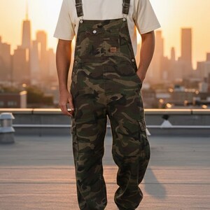 Men's slim-fit camouflage denim bib overalls with adjustable shoulder straps and multiple pockets in an urban streetwear design