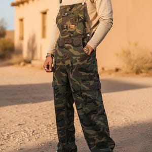 Men's slim-fit camouflage denim bib overalls with adjustable shoulder straps and multiple pockets in an urban streetwear design