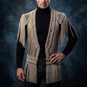 May include: A beige macrame waistcoat featuring intricate knotted patterns, a structured lapel, and long fringe detailing along the shoulders and hem. The garment is worn over a black long-sleeve turtleneck shirt and dark trousers, showcasing a layered design.