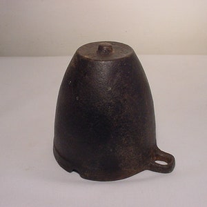 May include: A dark gray cast iron funnel with a handle. The funnel is shaped like a cone with a wide opening at the top and a narrow spout at the bottom.