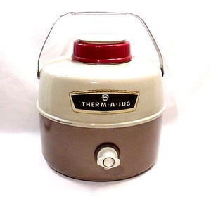 May include: A vintage Therm-A-Jug cooler in cream, brown, and red. It features a metal handle and a spigot. The text "Therm-A-Jug" is displayed on the front. This retro cooler is suitable for picnics and outdoor events.