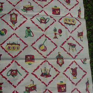 May include: A white fabric kitchen towel with a red diamond pattern. The towel is decorated with various kitchen-themed illustrations in red, green, and yellow. The illustrations include a clock, a teapot, a ladle, a stove, and a pitcher.