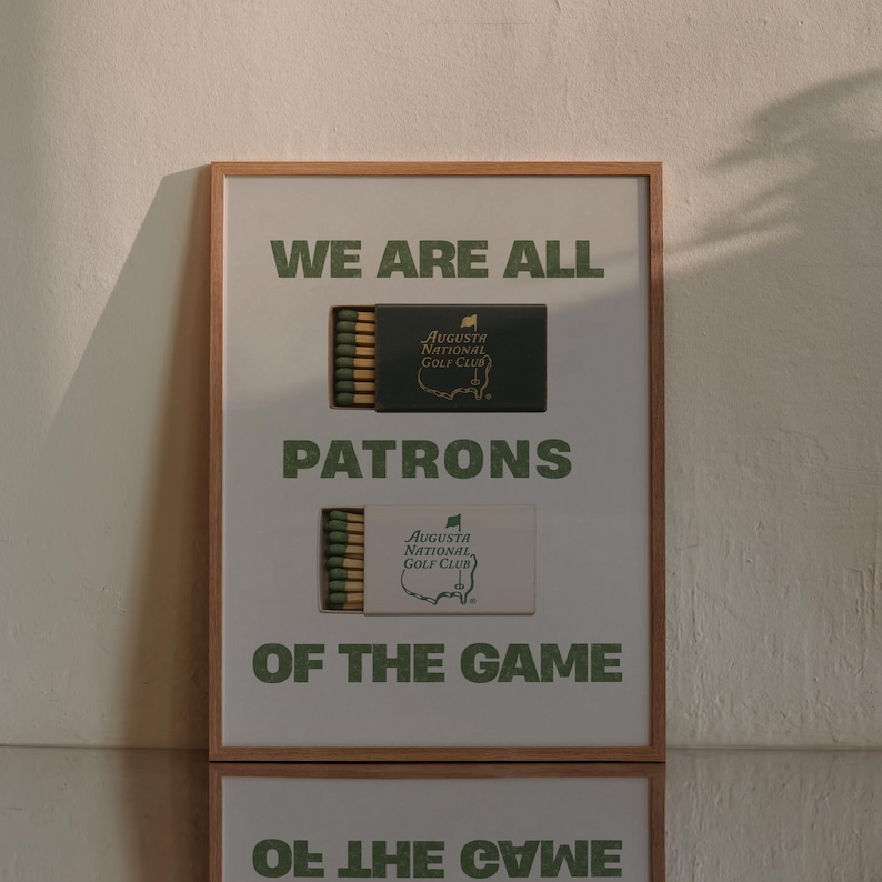 May include: A framed print with the text "We are all patrons of the game" and two matchboxes featuring the Augusta National Golf Club logo.