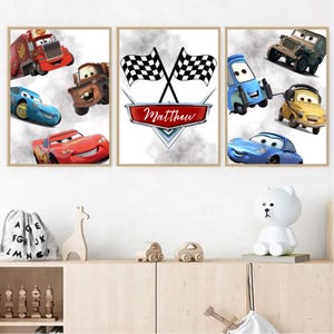 May include: Three framed prints featuring characters from the animated film Cars. The prints showcase various car characters, including Lightning McQueen, Mater, and Mack, with a central print displaying crossed checkered flags and the name "Matthew".