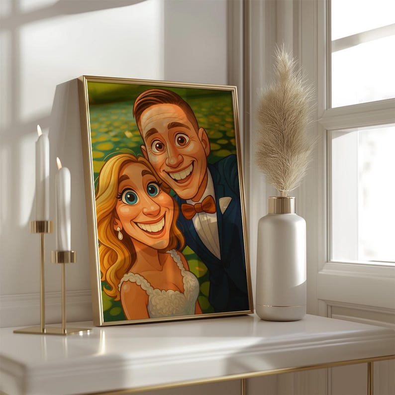May include: A framed cartoon portrait of a smiling couple, the man in a navy suit and bow tie, the woman in a white dress. The artwork is in a gold frame, resting on a white surface with candles and a vase.