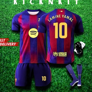 May include: A full football kit with a blue and maroon striped jersey, displaying the number 10 and the name "LAMINE YAMAL". The kit includes shorts, socks, and shin guards. The jersey features the Spotify logo and the UNHCR ACNUR logo. The words "KICKNKIT" and "FAST DELIVERY" are also visible.