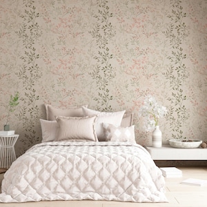 May include: A bedroom scene featuring a bed with a quilted comforter and pillows. The wallpaper has a floral pattern in shades of pink, green, and beige. A side table holds a vase of flowers. The room has a modern, minimalist design.