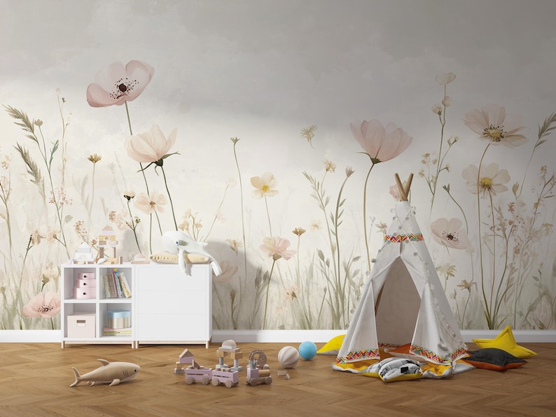 Pu&ograve; includere: Una cameretta con carta da parati floreale con grandi fiori rosa ed erbe alte. Un teepee bianco, un mobile contenitore bianco e vari giocattoli, tra cui un trenino, uno squalo e delle palle, sono sul pavimento in legno.