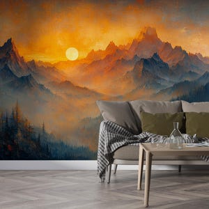 May include: A scenic wall mural depicting a mountain range at sunset. The artwork features a vibrant orange and yellow sky, with silhouetted mountains in shades of blue and gray. A sofa with pillows and a blanket is in front of the mural.