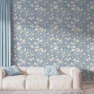 May include: A living room scene featuring a white sofa with two blue pillows, set against a backdrop of blue wallpaper with a cream-colored floral pattern. Light blue curtains frame the scene, creating a serene atmosphere.