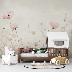 Pu&ograve; includere: Una cameretta per bambini con un letto in legno, una struttura a casetta bianca e un'auto giocattolo gialla. La stanza presenta una carta da parati floreale con fiori rosa e crema. Sono visibili anche un giocattolo a forma di orso bianco e un cuscino a forma di stella.
