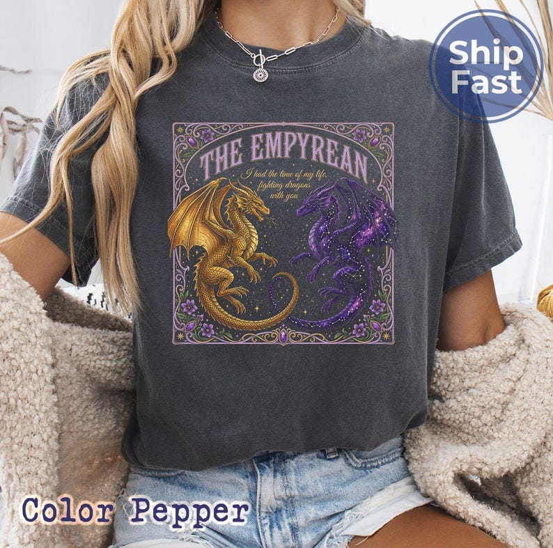 May include: Dark gray t-shirt featuring a graphic of two dragons, one gold and one purple, with the text "THE EMPYREAN" and "I had the time of my life fighting dragons with you." The design is framed with floral elements.