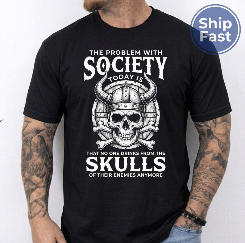 Puede incluir: Camiseta negra con un gr&aacute;fico blanco que presenta una calavera con un casco con cuernos, huesos cruzados y el texto "THE PROBLEM WITH SOCIETY TODAY IS THAT NO ONE DRINKS FROM THE SKULLS OF THEIR ENEMIES ANYMORE."