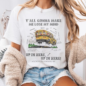 Può includere: Maglietta bianca con un'immagine di un autobus scolastico giallo e il testo "Y'all gonna make me lose my mind" e "Up in here, Up in here! #Schoolbusdriverlive".