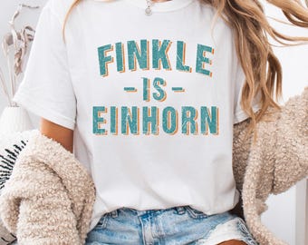 Finkle Is Einhorn Png, Funny Movie Quote Shirt, Bold Retro Text Design, Distressed Graphic Tee, Witty Pop Culture Apparel