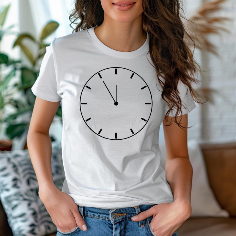 May include: White t-shirt with a black clock face design. The clock face shows the time as 12 o'clock.