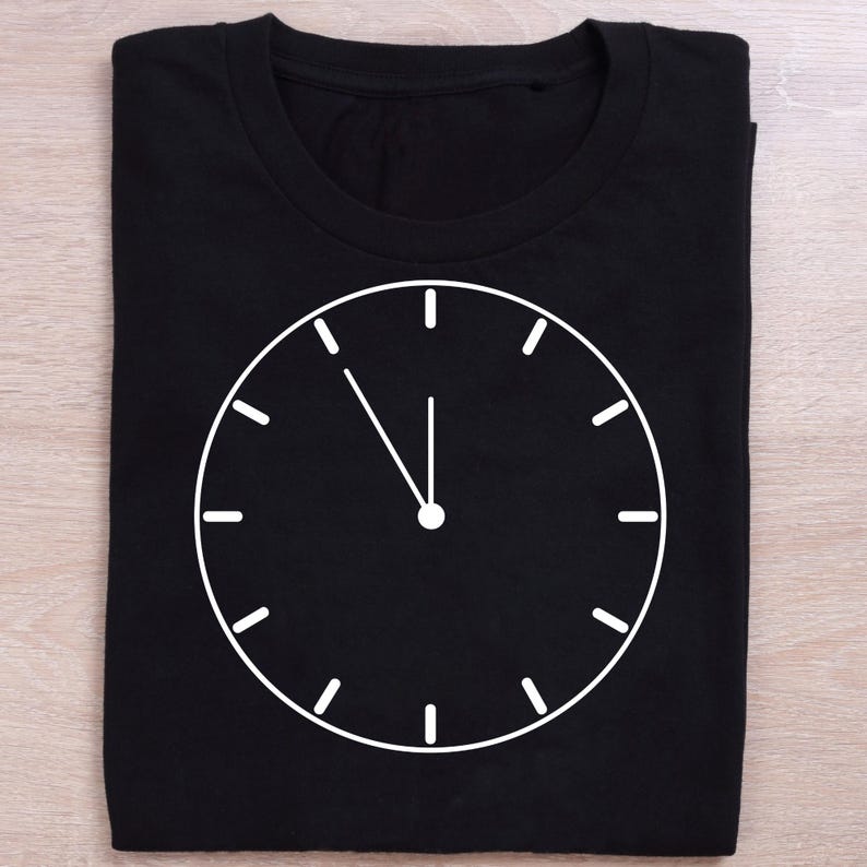May include: Black t-shirt with a white clock face design. The clock hands are pointing at 12 o'clock.