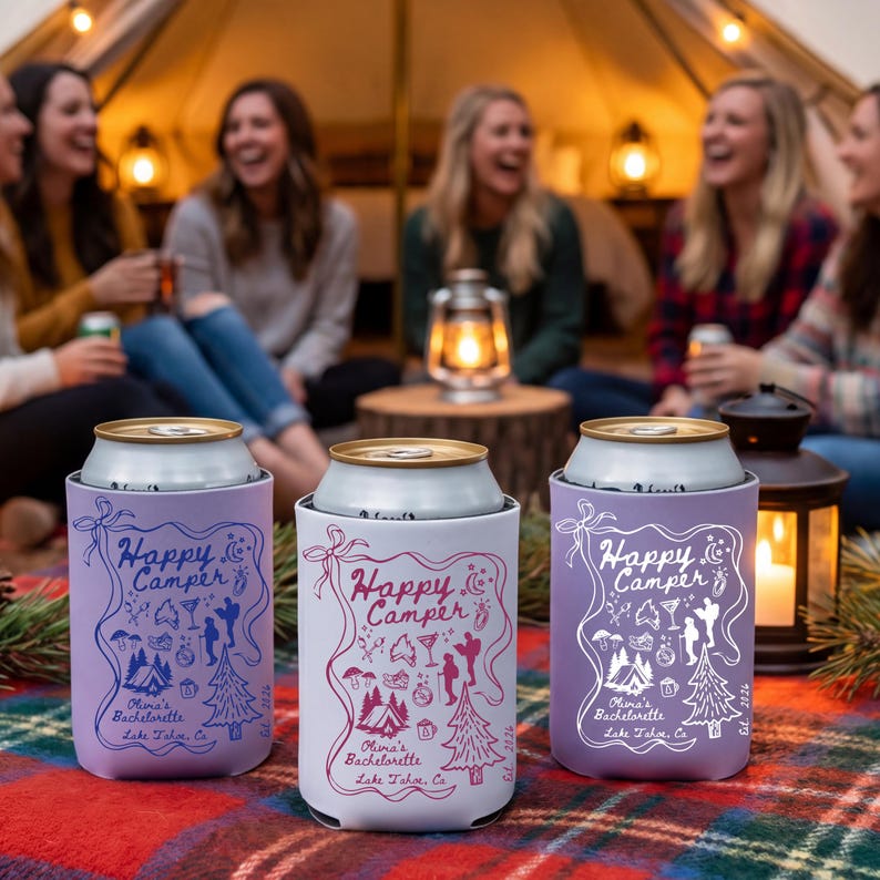 以下が含まれることがあります： 「Happy Camper」と「Olina's Bachelorette Lake Tahoe, Ca」の文字が入った、ラベンダーと白の3つの缶クーラー。クーラーは、キャンプやパーティーのアイコンを使ったお祭りデザインです。