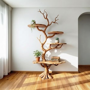 Op de afbeelding: Een houten boomvormige boekenplank met meerdere ronde planken. De planken bevatten potplanten en boeken. De unit is gemaakt van lichtbruin hout en staat op een houten vloer tegen een witte muur.