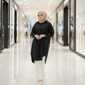 May include: A long-sleeved black button-down shirt with a collar and a curved hemline, paired with straight-leg white trousers and a beige headscarf. The outfit is completed with white flat shoes featuring a small bow detail on the front.