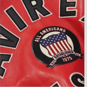 May include: Close-up of a red leather jacket with black and white lettering. A circular patch features the American flag and the words "ALL AMERICANS ESTABLISHED 1975 N.Y."