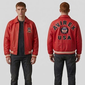 May include: A red leather jacket with a collared neckline and ribbed cuffs and hem. The jacket features a patch on the chest and the text "AVIREX USA" on the back. The jacket is worn with a dark gray t-shirt and dark wash jeans.