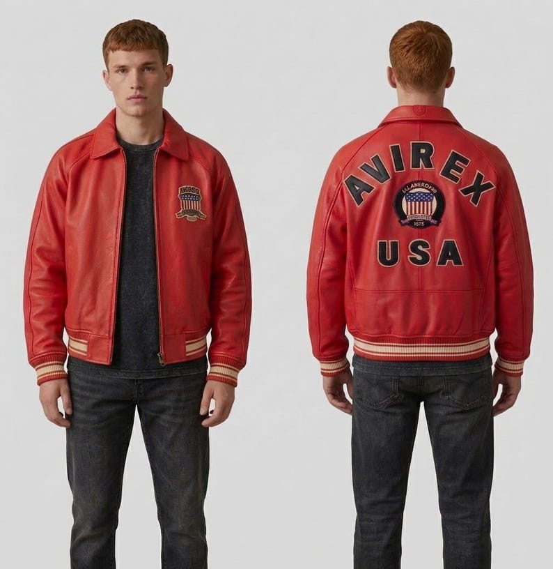 May include: A red leather jacket with a collared neckline and ribbed cuffs and hem. The jacket features a patch on the chest and the text "AVIREX USA" on the back. The jacket is worn with a dark gray t-shirt and dark wash jeans.