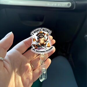 Bobine d'insigne de camping drôle de raton laveur, bières S'mores et clip d'identification de décisions douteuses, cadeau d'humour de feu de camp d'été pour les enseignants, les infirmières