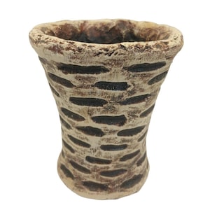 Puede incluir: Un pequeño macetero de cerámica de color crema con un diseño texturizado marrón. El macetero tiene una abertura ancha y una base ligeramente acampanada.