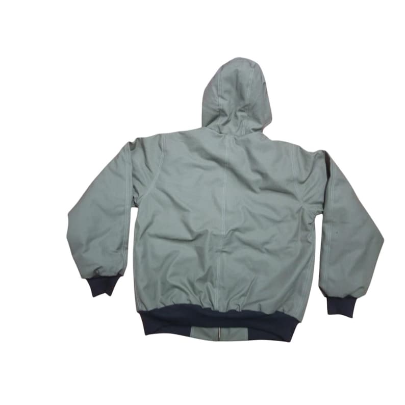 May include: A white ceramic mug with a black handle and the text "But First, Coffee" in a bold, black font. The mug is set against a blurred background, suggesting a cozy setting.