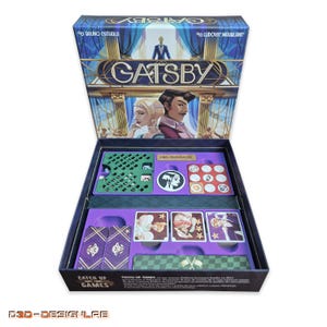 Op de afbeelding: Open bordspeldoos getiteld "Gatsby". De doos is donkerblauw met gouden letters en illustraties van personages. Binnenin bevatten paarse trays spelstukken, kaarten en tokens. Het spel is van Catch Up Games.