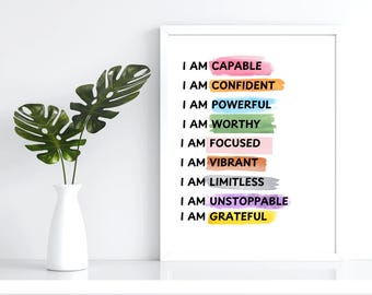 May include: A white framed print with the text "I am capable" in black lettering on a colorful watercolor background. The text is repeated nine times with different colors for each word.