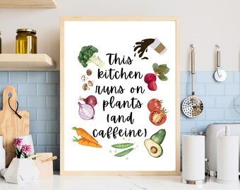 Könnte beinhalten: Weißer druckbarer Kunstdruck mit schwarzem Text, der "This kitchen runs on plants (and caffeine)" lautet. Der Text ist von einem Kreis aus bunten Gemüse und einer Kaffeetasse mit auslaufendem Kaffee umgeben.