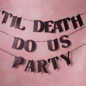 May include: Black glitter banner reading "Til Death Do Us Party" strung on three lines. The banner is set against a pink hexagonal tile backdrop. Ideal for a wedding or Halloween celebration.