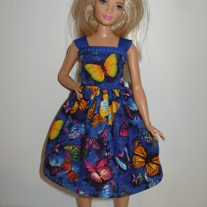 May include: A blue dress with a butterfly print. The dress has a square neckline and thin straps. The dress is made of a soft, comfortable fabric and is perfect for a summer day.