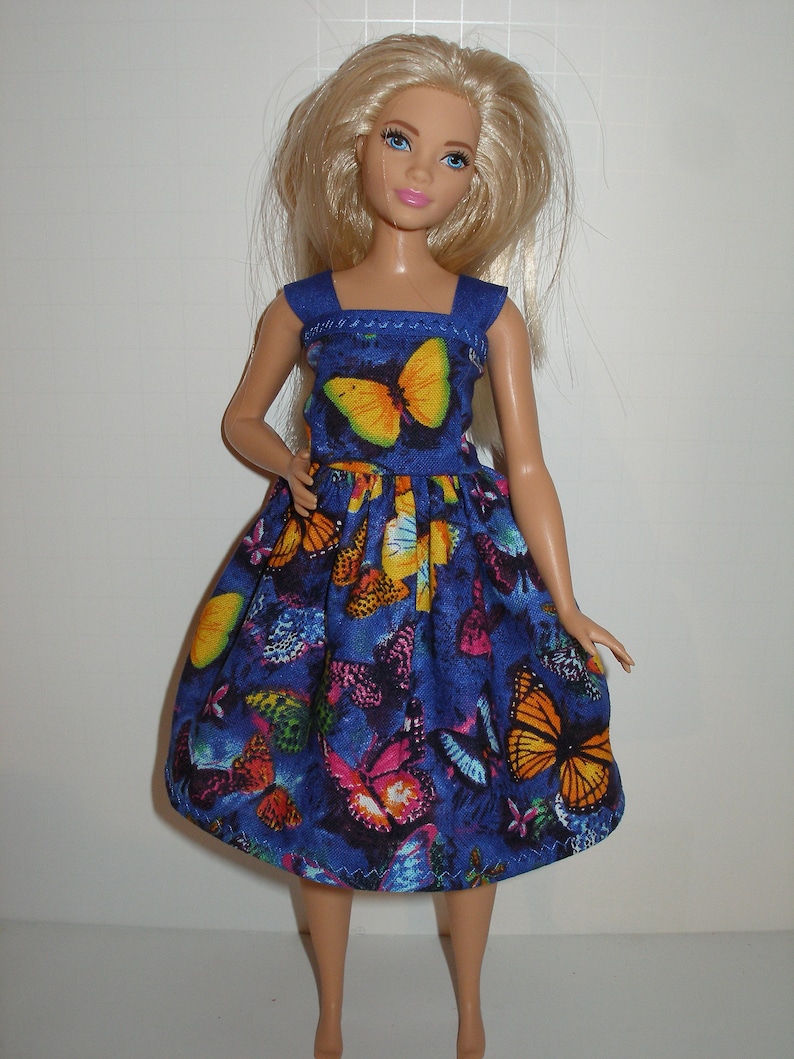 May include: A blue dress with a butterfly print. The dress has a square neckline and thin straps. The dress is made of a soft, comfortable fabric and is perfect for a summer day.