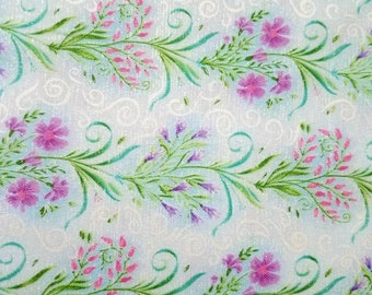 May include: A light blue fabric featuring a repeating pattern of green vines with pink and purple flowers and white swirls. A purple measuring tape is positioned at the bottom, showing measurements from 18 to 22 inches.