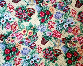 May include: A fabric pattern featuring a repeating design of colorful flower arrangements in woven baskets set against a light beige background with a subtle, diagonal lattice texture. The floral clusters include red, white, blue, and yellow blossoms with green leaves.