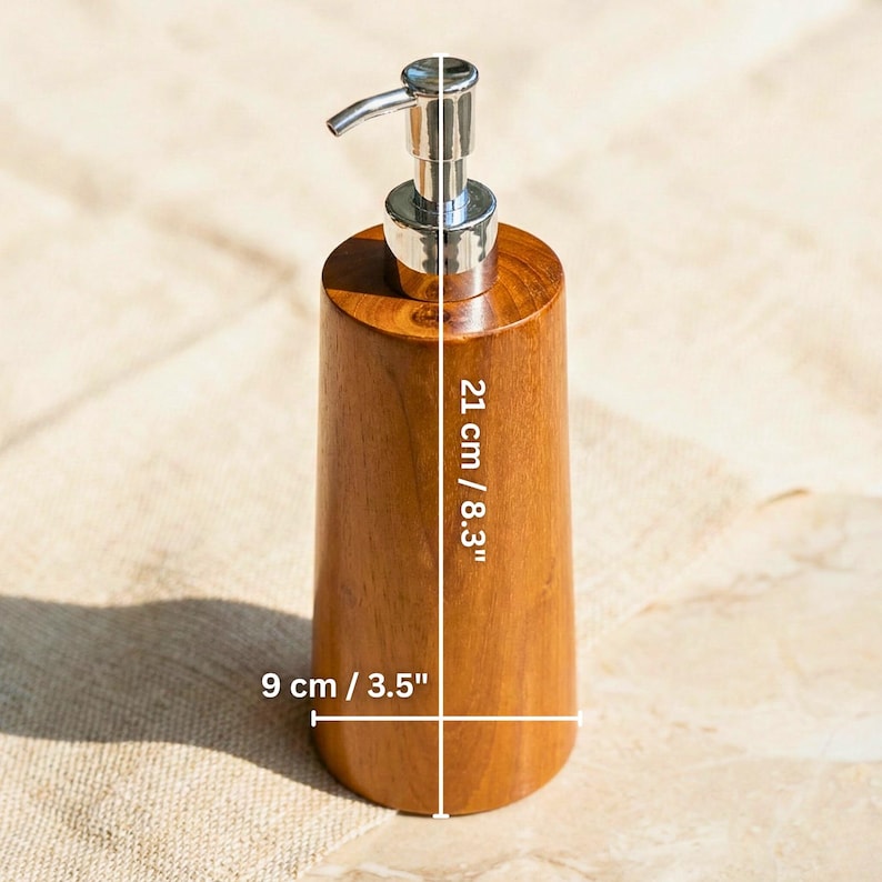 May include: A wooden soap dispenser with a stainless steel pump. The dispenser is 8.3 inches tall and 3.5 inches wide. The wood has a warm, natural tone. The dispenser is designed for liquid soap or lotion.