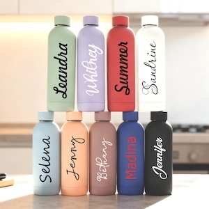 May include: A collection of insulated water bottles in various colors, including green, purple, red, white, blue, peach, and black. Each bottle features a different name in a stylish script font. The bottles are arranged in a stacked formation.