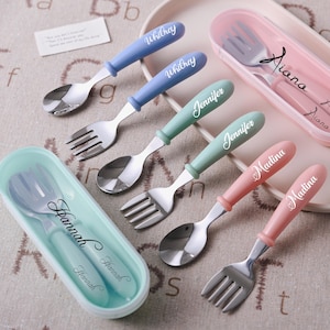 May include: A collection of personalized stainless steel forks and spoons with pastel-colored handles. Each utensil is engraved with a name, and some are stored in matching cases. The names include Whitney, Jennifer, Madina, Hannah, and Aiana.
