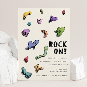 Peut inclure: Une invitation crème avec des prises d'escalade colorées et les mots "ROCK ON!". L'invitation est pour le 10e anniversaire d'Ashleigh, avec la date, l'heure et le lieu indiqués sous le texte. Les informations RSVP sont en bas.