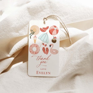 May include: A white thank you tag with a summer theme. The tag features a pink flamingo, a blue beach umbrella, a watermelon, a donut, a beach ball, and a straw hat. The text on the tag reads "Thank you" and "Love Evelyn".