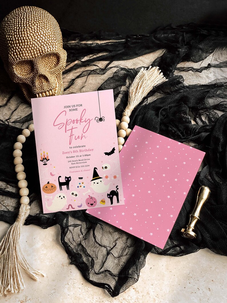 Puede incluir: Invitaciones rosas para una fiesta de Halloween con el texto "Spooky Fun" e ilustraciones tem&aacute;ticas de Halloween. La invitaci&oacute;n incluye detalles para una celebraci&oacute;n de cumplea&ntilde;os. Una calavera dorada y cuentas decorativas en el fondo.