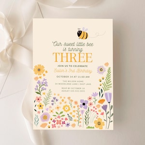 Może przedstawiać: Zaproszenie urodzinowe z motywem pszczoły i kwiatów. Tekst brzmi "Our sweet little bee is turning THREE". Dodatkowy tekst zawiera datę, godzinę i miejsce przyjęcia.
