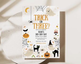 May include: A white invitation with black and orange Halloween themed illustrations. The text reads "Trick or Three?" and "Join us to celebrate Noah's 3rd Boo-Day, October 15 at 1:00pm, 245 South Bend Drive, East Riverview, RSVP Ellie 555.1234, Costumes & Chaos!"